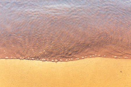 Soft wave of the sea on the sandy beach. Sea wave and gold sand.の写真素材