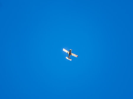 Small ultralight airplane with overhead wing and single propeller flying in sunset sky. Such aircraft are used for recreational, sport and flight training.の写真素材
