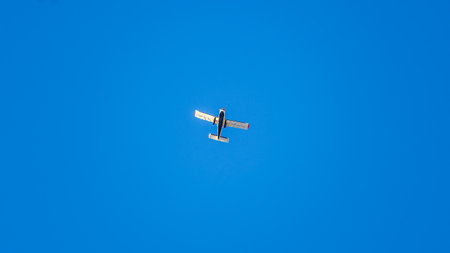 Small ultralight airplane with overhead wing and single propeller flying in sunset sky. Such aircraft are used for recreational, sport and flight training.の写真素材