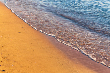 Soft wave of the sea on the sandy beach. Sea wave and gold sand.