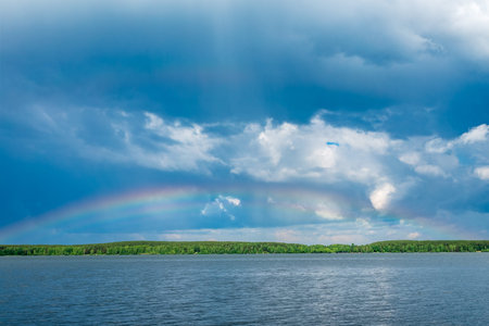 Rainbow over Blue lake with cloudy skyの写真素材