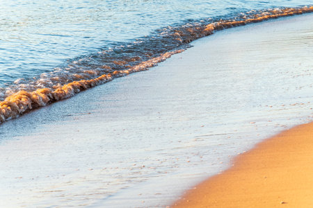 Soft wave of the sea on the sandy beach. Sea wave and gold sand.