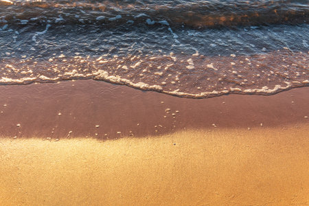 Soft wave of the sea on the sandy beach. Sea wave and gold sand.の写真素材