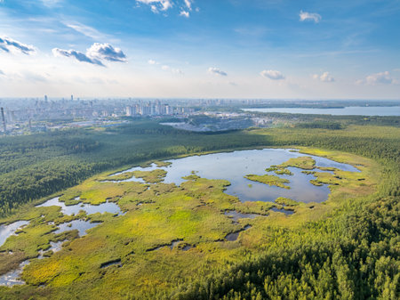 Big lake with green shores in bright sun light and city on horizon, aerial landscape. Recreation concept. Sky reflection. Ecology in Europe. Aerial view. Lake Shartash and Yekaterinburg, Russiaの写真素材