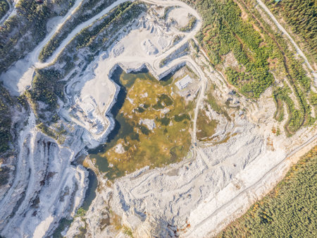 Stone quarry in the forest. Flying over the summer mixed forest during sunset. Stone crushing plant. The surroundings of Yekaterinburg. Ural, Russia, Aerial Viewの写真素材