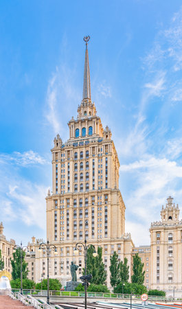 Illuminated high-rise stalinist building near river at summer sunset in Moscow, Russia. Historic name is Hotel Ukraine. Spring or summer urban cityscape.の写真素材