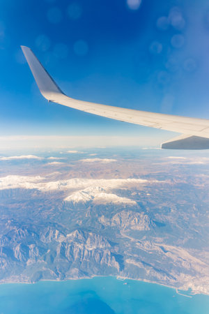 View from the airplane window of the mountains and sea resort with corals. Flight. View from the airplane to sea and desert mountainsの写真素材