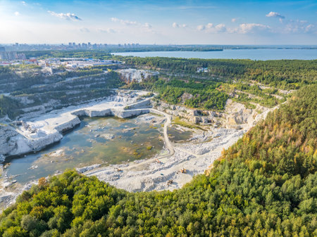 Stone quarry in the forest. Flying over the summer mixed forest during sunset. Stone crushing plant. The surroundings of Yekaterinburg. Ural, Russia, Aerial Viewの写真素材