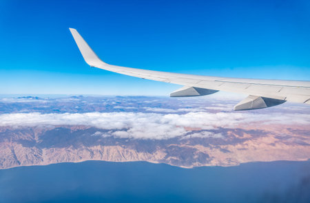 View from the airplane window of the mountains and sea resort with corals in Egypt. View from the...