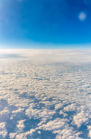 View from the airplane window at a beautiful cloudy sky and the airplane wing.の写真素材