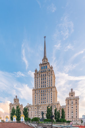 Illuminated high-rise stalinist building near river at summer sunset in Moscow, Russia. Historic name is Hotel Ukraine. Spring or summer urban cityscape.の写真素材