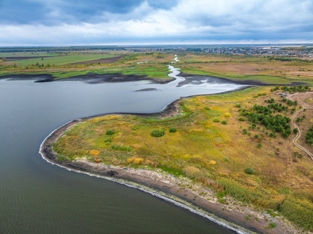 Colorful autumn forest with trees on the shore of a lake - top aerial view. Bright landscape autumn background with a bird's eye view. Copy Space.の写真素材