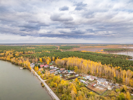 Colorful autumn forest with trees on the shore of a blue lake - top aerial view. Bright landscape autumn background with a bird's eye view. Copy Space.の写真素材