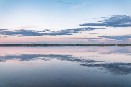 Blue lake with cloudy sky, natural background. Lake with forest on the shores at summer