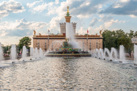 Moscow, Russia - August 4, 2023: Stone Flower fountain and pavilion Ukraine in Exhibition of economic achievements, VDNKh, Moscow, Russia. Splashes of water against light background.のeditorial素材