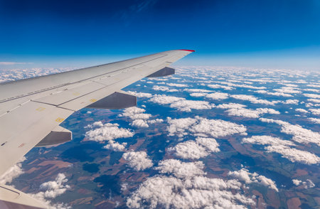View from the airplane window at a beautiful cloudy sky and the airplane wing. Earth and sky as seen through window of an airplane.の写真素材