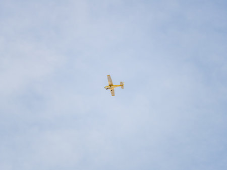 Small ultralight airplane with overhead wing and single propeller flying in sunset sky. Such aircraft are used for recreational, sport and flight training.の写真素材