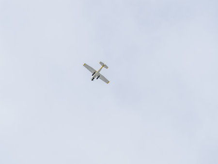 Small ultralight airplane with overhead wing and single propeller flying in sunset sky. Such...
