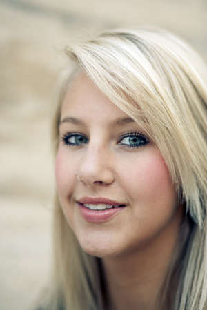 Attractive blond young woman smiles towards the camera. Vertical shot.の写真素材