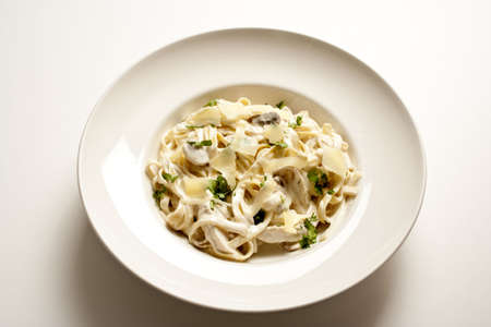 Bowl of Fettuccine alfredo on a plain white tabletop.  Horizontal shot.の写真素材