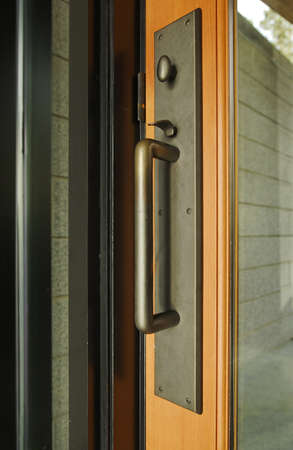 A brass door handle with turning lock knob and thumb latch. Vertical shot.の写真素材