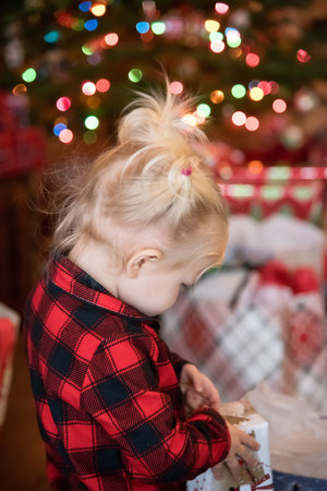 little girl opening gifts on Christmas morning