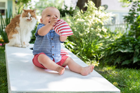 little kid playing cornhole with family in backyard on fourth of July