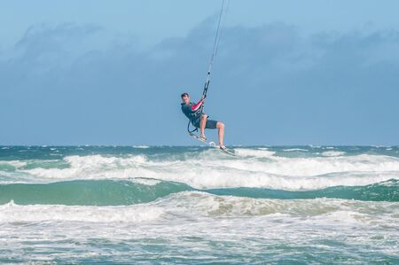MOSSELBAY, SOUTH AFRICA - DECEMBER 31, 2014: A stormwind lifts an unidentified windsurfer high above the waves at the Klein Brakrivier beachのeditorial素材