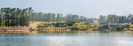 CAPE TOWN, SOUTH AFRICA - DECEMBER 18, 2014: Early morning panorama of houses next to a dam with jetty on the Wedderville Estate near Sir Lowrys Passのeditorial素材