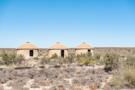 Three unoccupied railway worker rondavels next to the inoperative railway line between Carnavon and Williston in the Northern Cape Karoo region of South Africaの写真素材