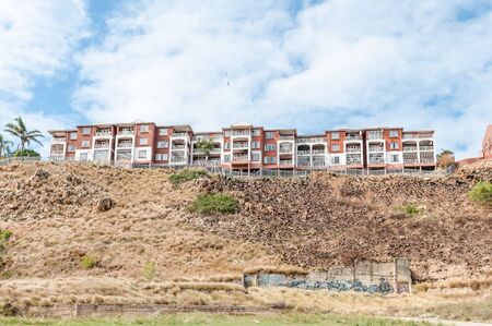 PORT ELIZABETH, SOUTH AFRICA - FEBRUARY 27, 2016: A block of flats on a hill overlooking the central parts of Port Elizabeth. Street art is visible belowのeditorial素材
