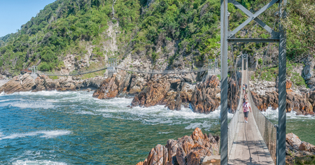 STORMS RIVER MOUTH, SOUTH AFRICA - FEBRUARY 29, 2016:  Unidentified tourists on the suspension bridge over the mouth of the Storms Riverのeditorial素材