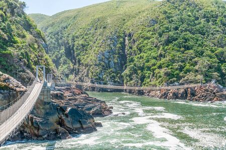 STORMS RIVER MOUTH, SOUTH AFRICA - FEBRUARY 29, 2016:  Unidentified tourists on one of the suspension bridges at the mouth of the Storms Riverのeditorial素材