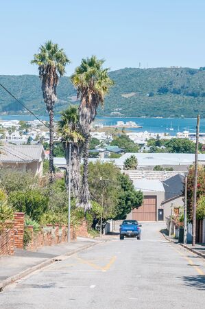 KNYSNA, SOUTH AFRICA - MARCH 3, 2016: A street view of Knysna with the Regional Office of the South African National Parks Board on the historic Thesens Island in the backのeditorial素材