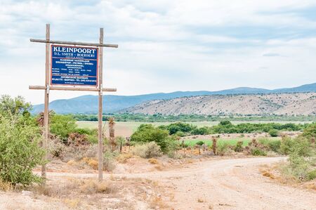 BAVIAANSKLOOF, SOUTH AFRICA - MARCH 6, 2016: Signboard for a farm and business in the Baviaanskloof (baboon valley). The road and farm land are visibleのeditorial素材