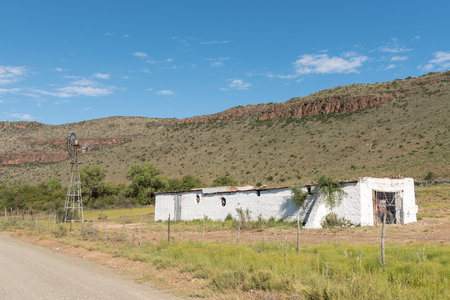 NIEU BETHESDA, SOUTH AFRICA - MARCH 22, 2017: An old barn and windmill near Nieu-Bethesda, an historic village in the Eastern Cape Provinceのeditorial素材