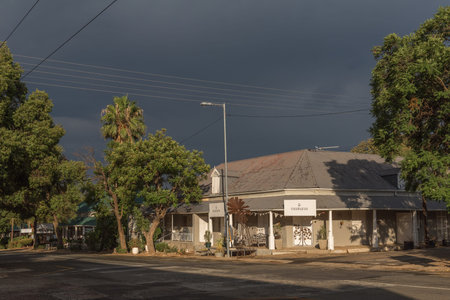 DE RUST, SOUTH AFRICA - MARCH 23, 2017: A building in De Rust at sunset against a backdrop of dark cloudsのeditorial素材