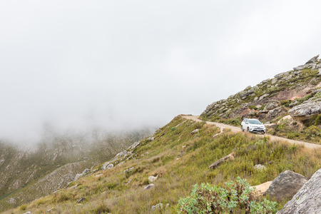 SWARTBERG, SOUTH AFRICA - MARCH 24, 2017: A vehicle on the historic Swartberg Pass (black mountain pass). The pass is a national monumentのeditorial素材