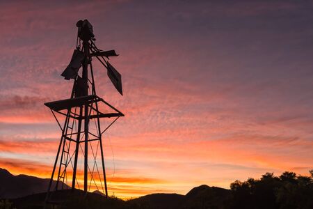 Silhouette of a broken windmill against sunset on a farm near Montagu in the Western Cape Provinceの写真素材