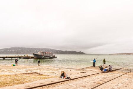 LANGEBAAN, SOUTH AFRICA - MARCH 31, 2017: A boat anchored at a pier and anglers at a boat launching site at Langebaan on the Atlantic Coast of the Western Cape Provinceのeditorial素材