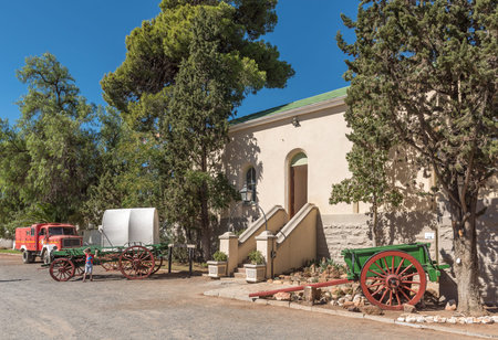 MATJIESFONTEIN, SOUTH AFRICA - APRIL 2, 2017:  A street scene with historic fire truck, oxwagon and horse drawn cart in front of the historic station building in Matjiesfonteinのeditorial素材