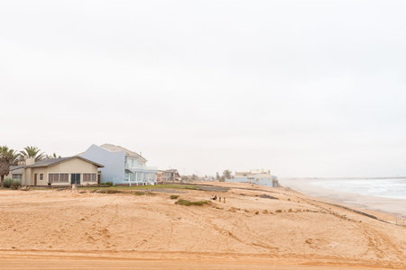 HENTIES BAY, NAMIBIA - JUNE 29, 2017: Holiday homes in the mist on a dune in Henties Bay, a well known holiday town on the Skeleton Coast of Namibiaのeditorial素材