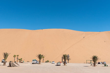 WALVIS BAY, NAMIBIA - JULY 2, 2017: Picnic spots and unidentified tourists on dune 7 at Walvis Bay in the Namib Desert on the Atlantic Coast of Namibiaのeditorial素材
