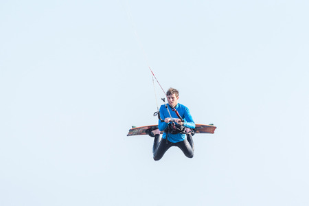 WALVIS BAY, NAMIBIA - JULY 2, 2017: An unidentified kite surfer airborne at the lagoon at Walvis Bay in the Namib Desert on the Atlantic Coast of Namibiaのeditorial素材