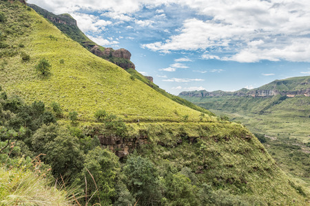 ROYAL NATAL NATIONAL PARK, SOUTH AFRICA - MARCH 15, 2018: An unidentified hiker on the Tugela Gorge hiking trail against the backdrop of a golden grass slopeのeditorial素材