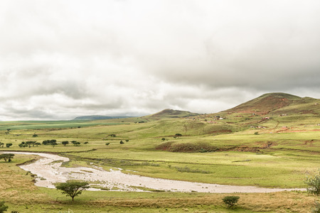 The Tugela River with a township in the back. The river forms the border of the Maloti Drakensberg Park at this pointの写真素材