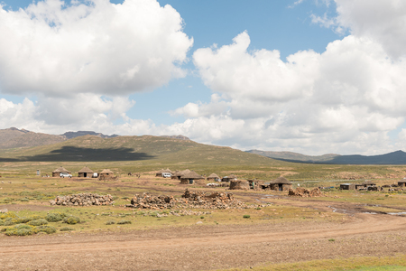 BLACK MOUNTAIN PASS, LESOTHO - MARCH 24, 2018: The Mamokae village at the foot of the Black Mountain Pass. Stone huts and tourist vehicles are visibleのeditorial素材