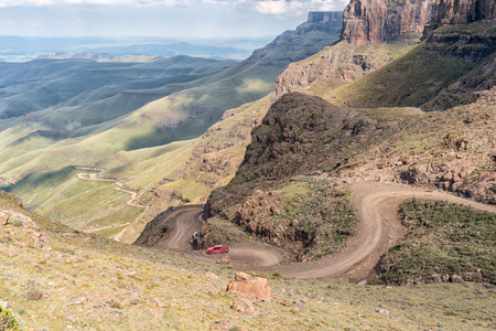 SANI PASS, SOUTH AFRICA - MARCH 24, 2018: Hairpin bends in the Sani Pass as seen from Sani Mountain Lodge. A four-wheel drive vehicle is visible on the passのeditorial素材