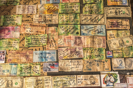 SANI TOP, LESOTHO - MARCH 24, 2018: Banknotes from all over the world in the pub at Sani Mountain Lodge at the top of the Sani Pass. The lodge claims the title of highest pub in Africaのeditorial素材