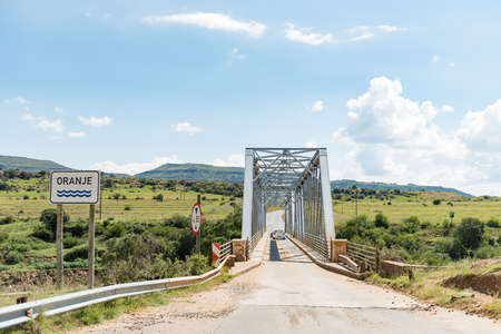 A vehicle is crossing the single lane bridge over the Orange River between Sterkspruit and Zastronの写真素材